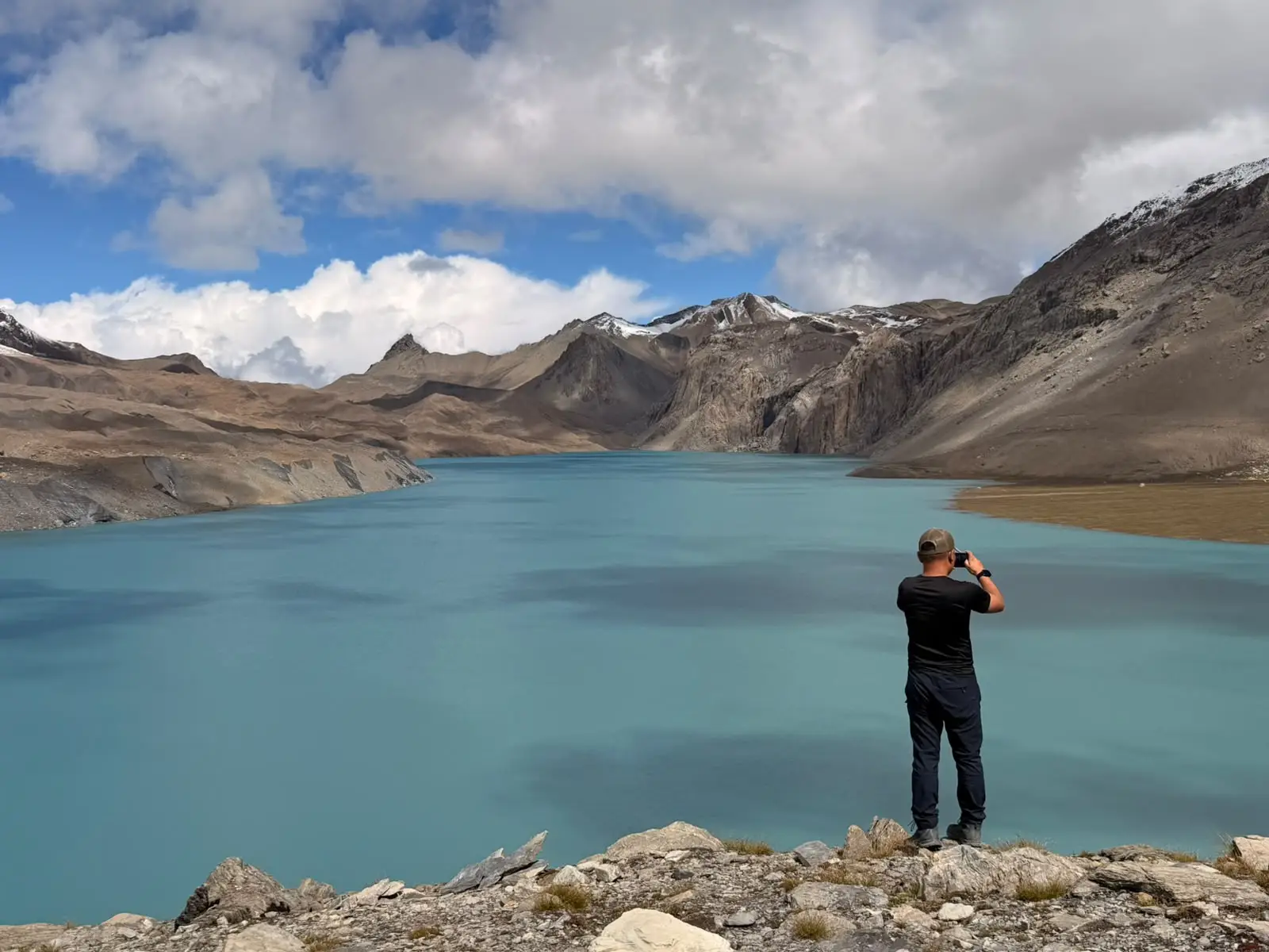 Annapurna Circuit Trek via Tilicho Lake – 15 days rekker overlooking the turquoise waters of Tilicho Lake surrounded by rugged snow-covered mountains in Nepal.