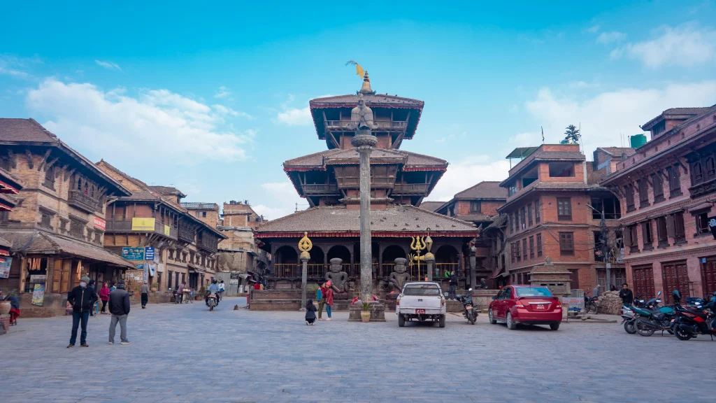 Traditional brick buildings and a multi-tiered pagoda temple set in Bhaktapur Durbar Square within the Kathmandu Valley.