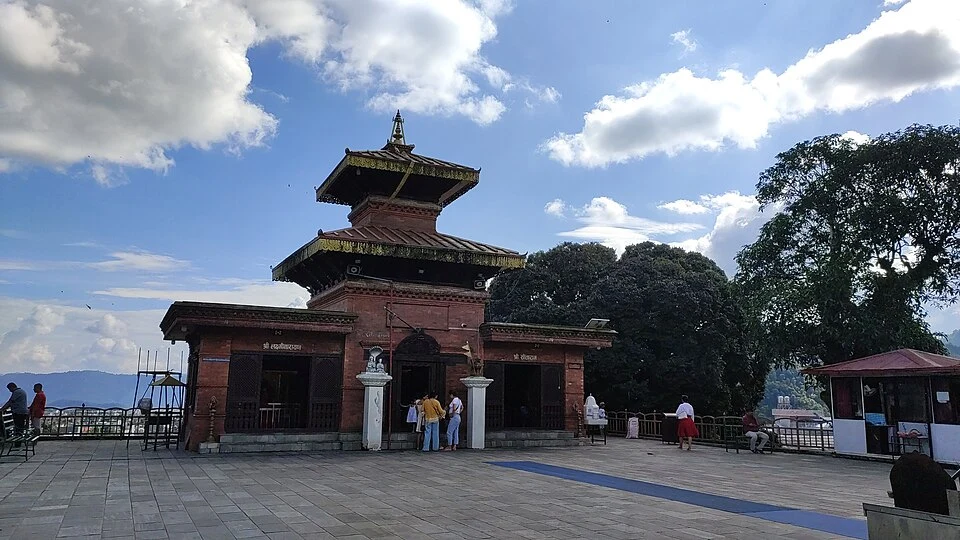 Traditional pagoda-style structure of Bindhyabasini Temple in Pokhara under a blue sky.