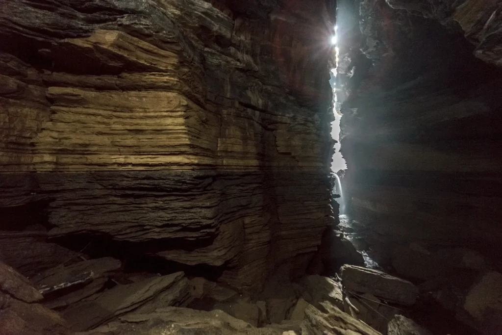 Natural rock formations and sunlight streaming through a narrow opening in Gupteshwor Mahadev Cave in Pokhara.