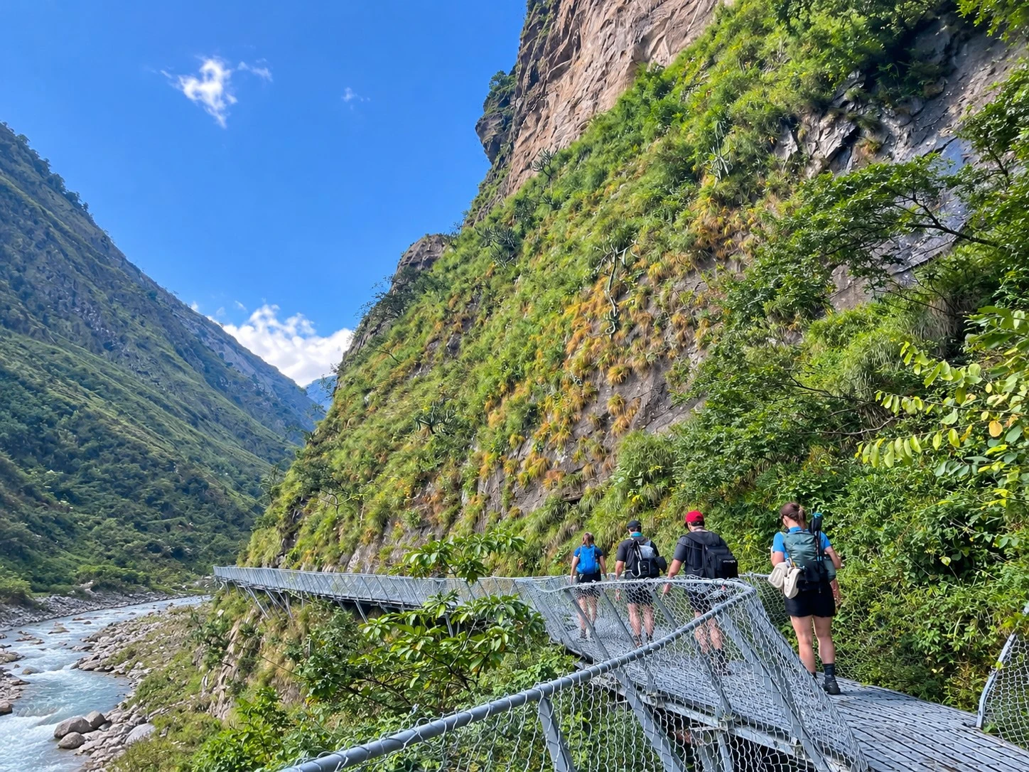 Hikers on a Cliffside Suspension Walkway